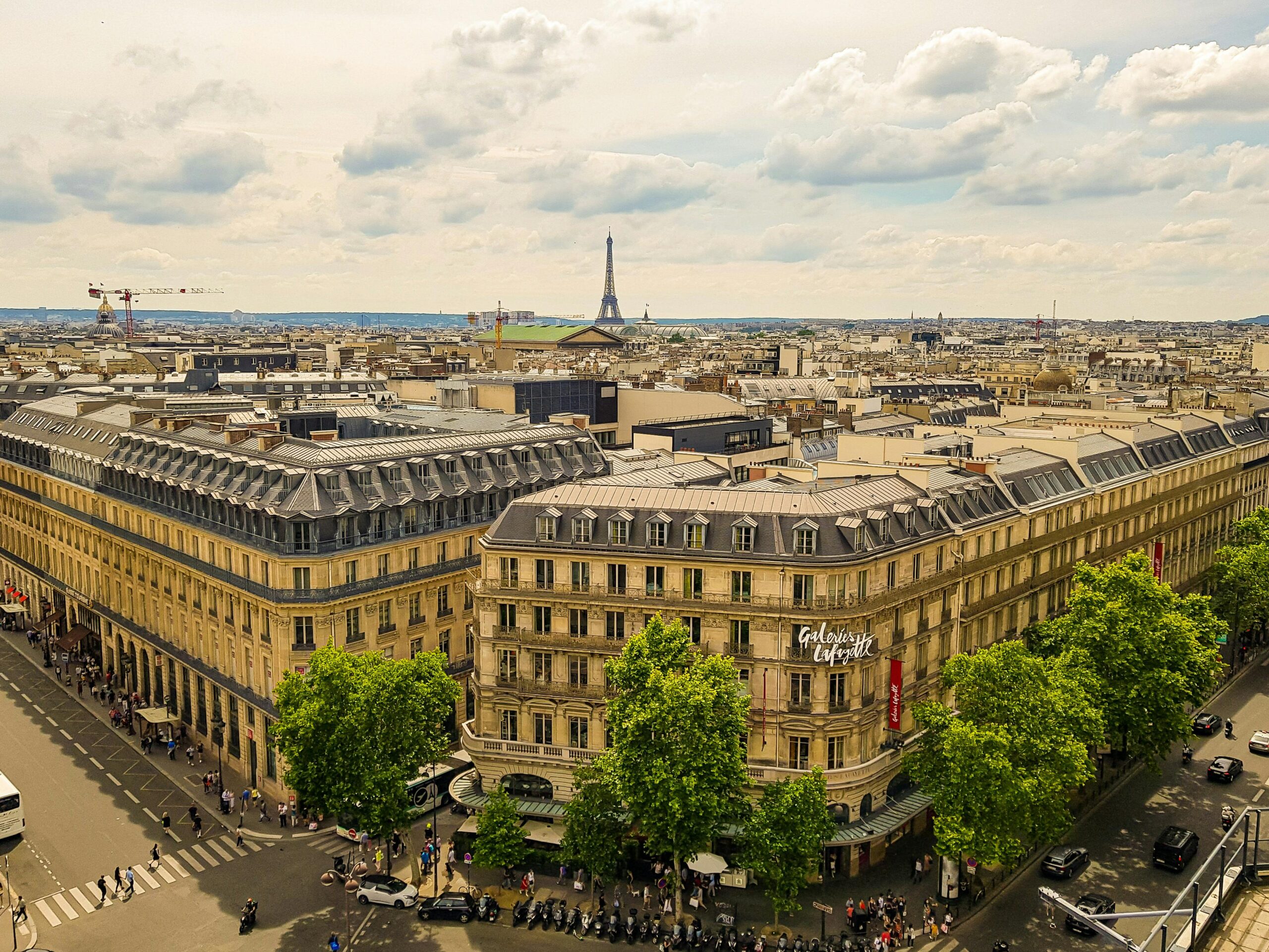 Aerial view of Paris with Galeries Lafayette and Eiffel Tower in the background.
